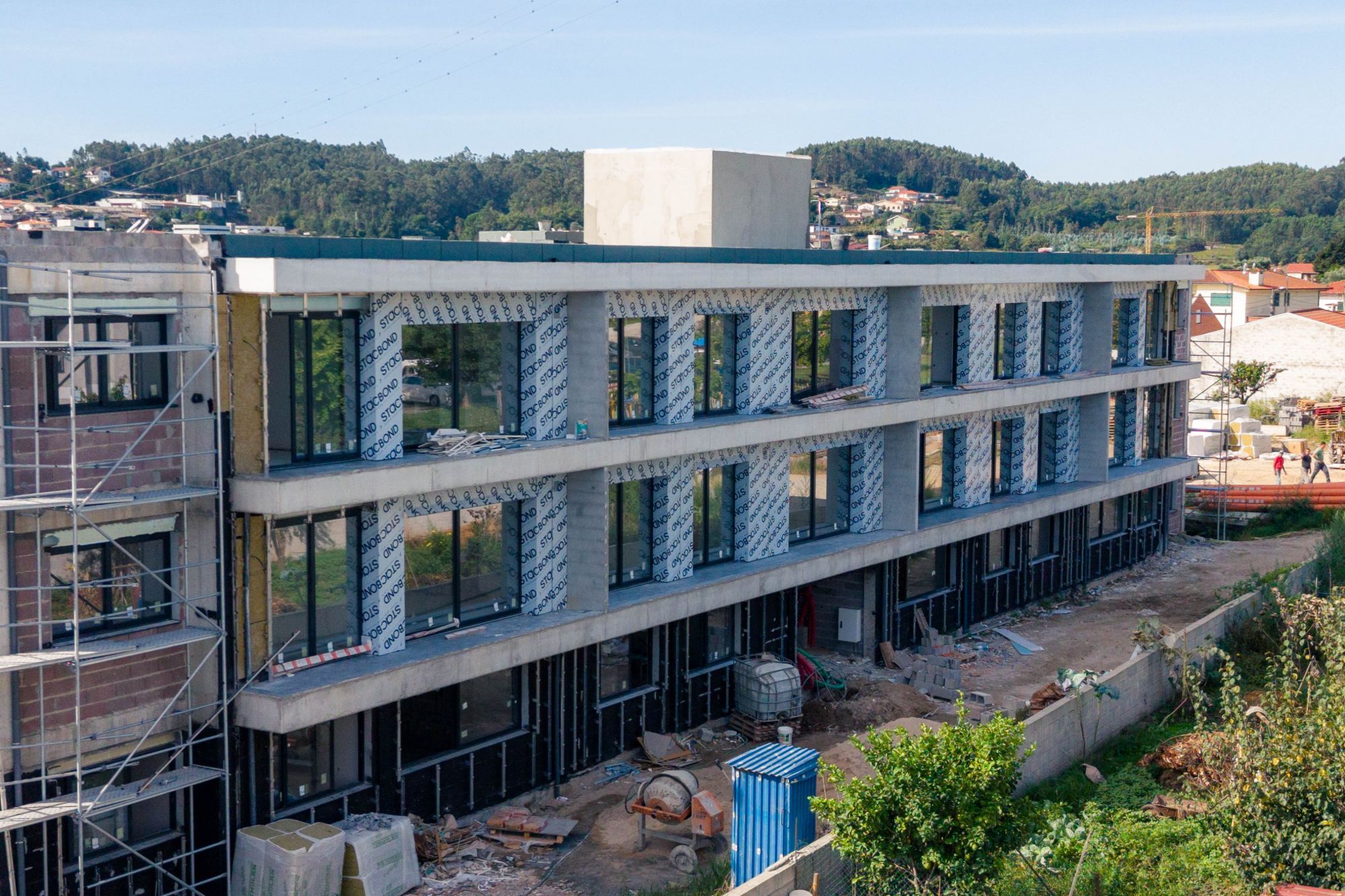 Edifício em construção com painéis e envidraçados, visto de drone